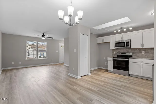 a large kitchen with hardwood floor stainless steel appliances and wooden floor