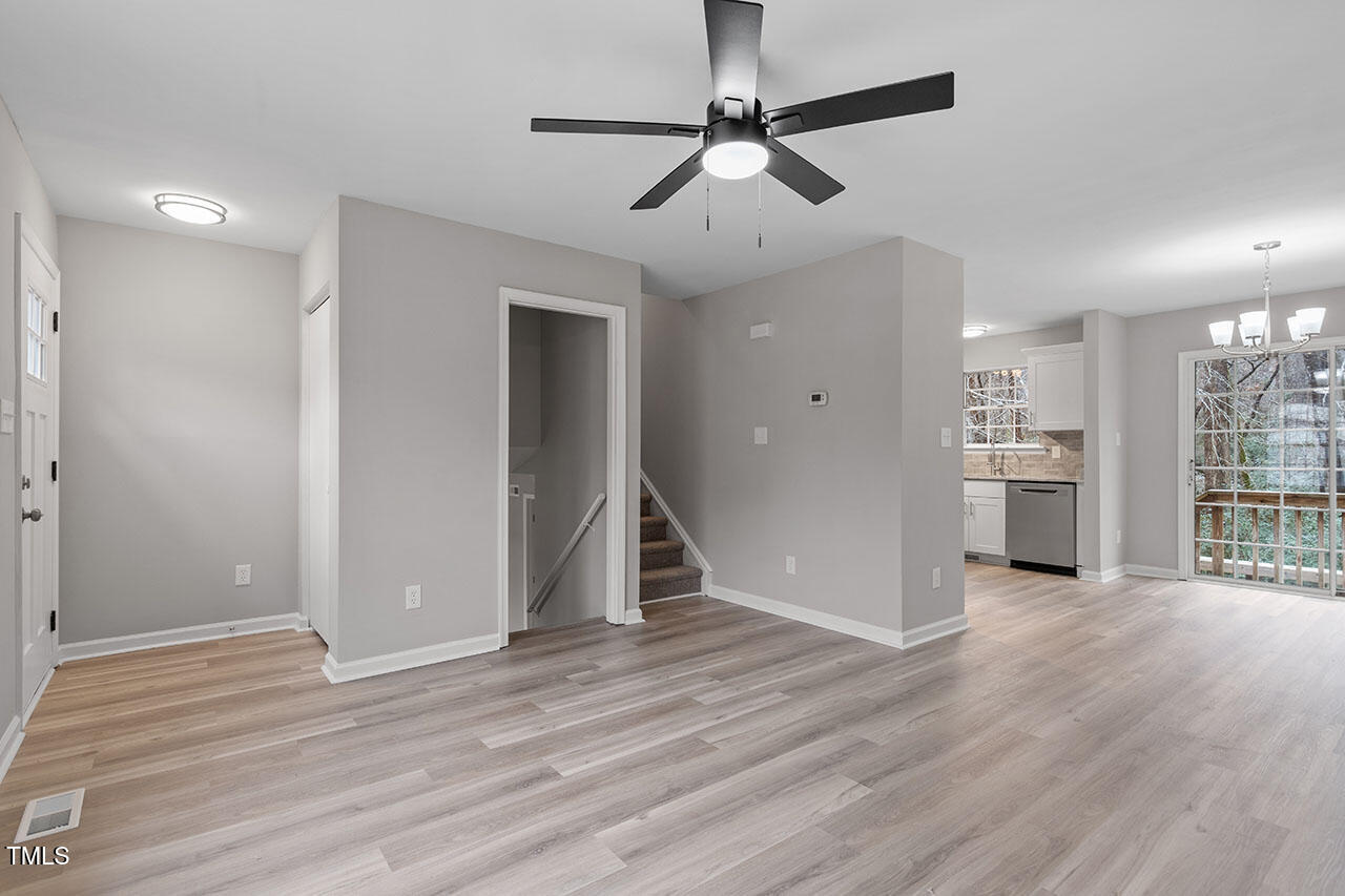 8341 Wynewood Court Raleigh, NC 27616 - Photo 17 of 35 a view of an empty room with wooden floor and a ceiling fan