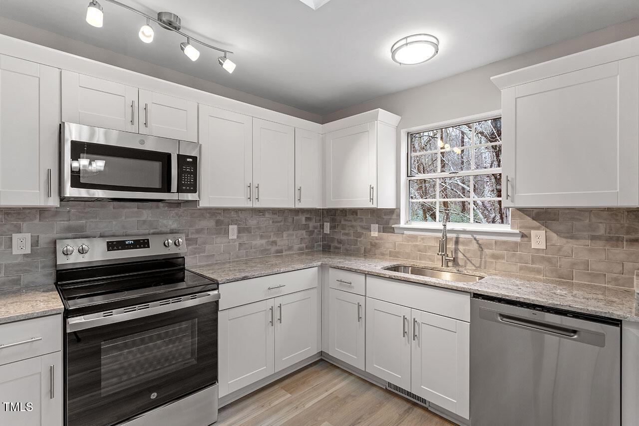8341 Wynewood Court Raleigh, NC 27616 - Photo 2 of 35 a kitchen with stainless steel appliances granite countertop a sink dishwasher a stove microwave and oven with cabinets