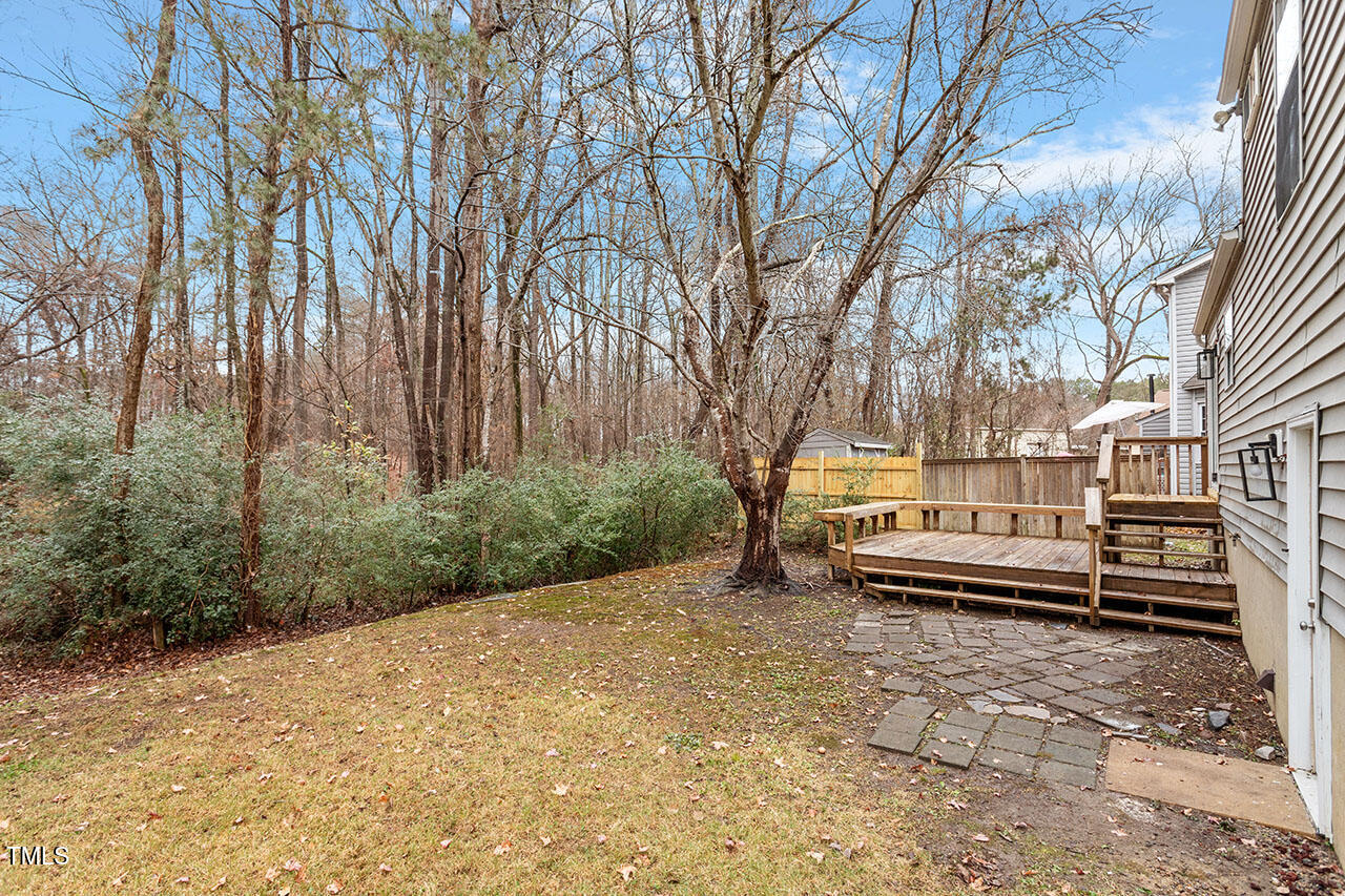 8341 Wynewood Court Raleigh, NC 27616 - Photo 28 of 35 a backyard of a house with large trees and wooden fence