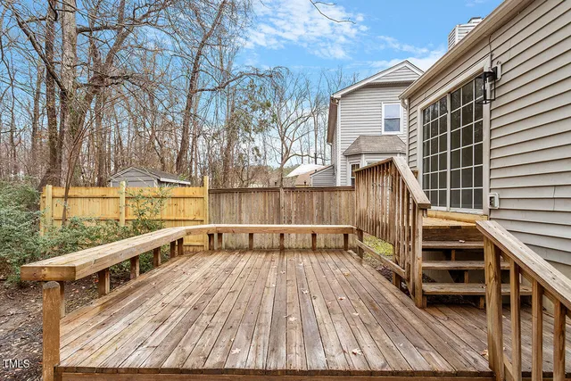 a view of a balcony with wooden floor and fence