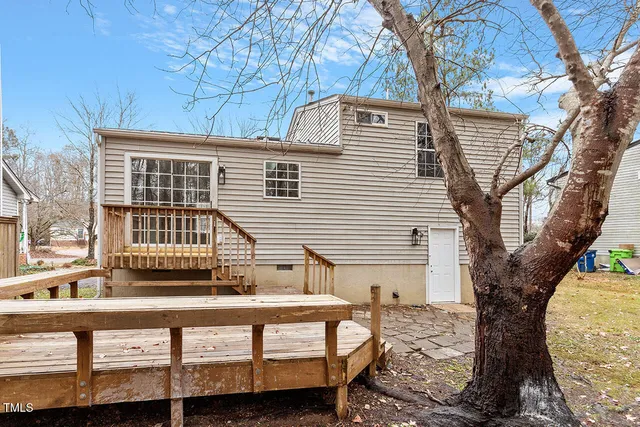 a front view of a house with a tree