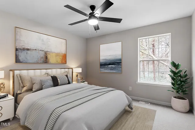 a bedroom with a large bed and a potted plant