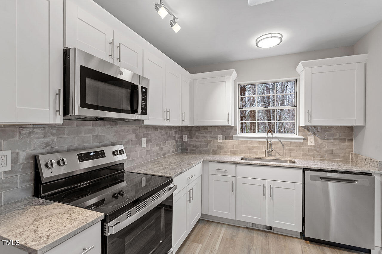 8341 Wynewood Court Raleigh, NC 27616 - Photo 6 of 35 a kitchen with granite countertop cabinets stainless steel appliances and a sink