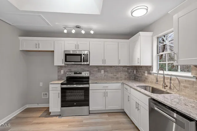 a kitchen with sink a microwave and cabinets
