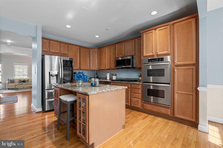 1556 Penzance Way Hanover, MD 21076 - Photo 12 of 40 a kitchen with kitchen island granite countertop wooden cabinets a stove a sink and a stainless steel appliances with wooden floor