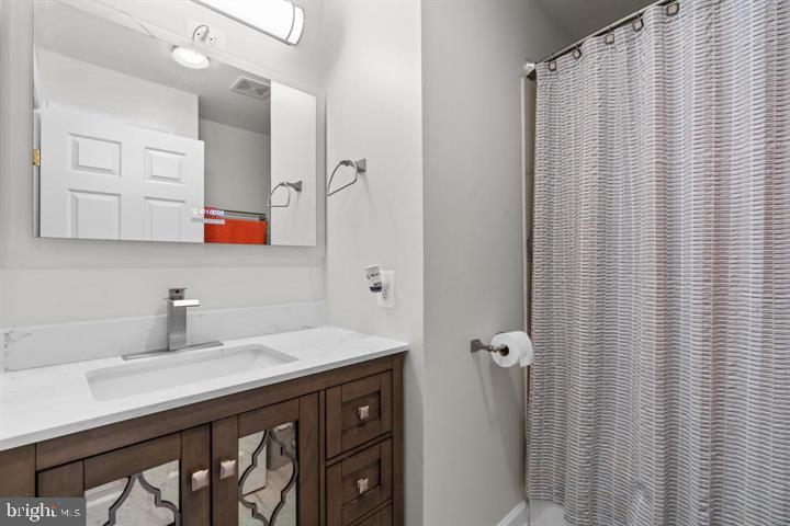 1556 Penzance Way Hanover, MD 21076 - Photo 28 of 40 a bathroom with a sink a mirror a vanity and a shower
