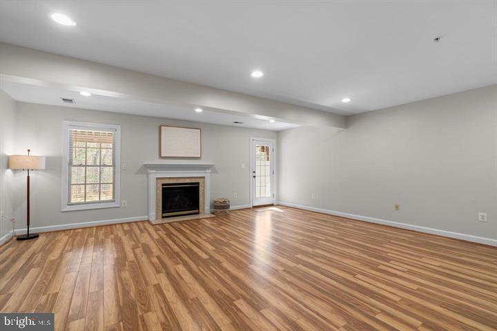 1556 Penzance Way Hanover, MD 21076 - Photo 33 of 40 an empty room with wooden floor fireplace and windows
