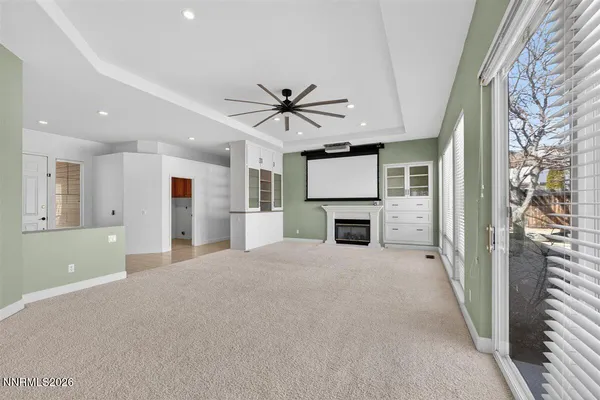 a view of a livingroom with a kitchen and a ceiling fan