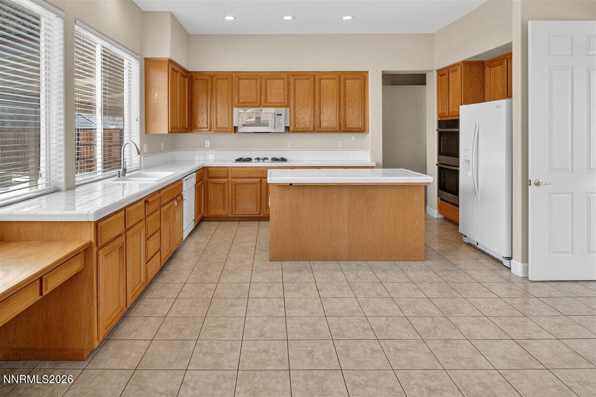 2214 St George Way Carson City, NV 89703 - Photo 18 of 57 a large kitchen with stainless steel appliances granite countertop a stove a sink and a refrigerator