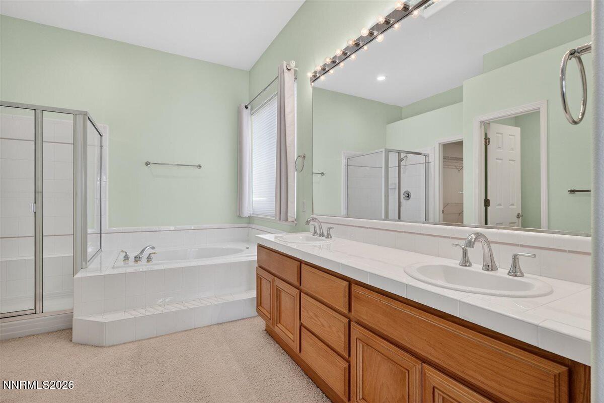2214 St George Way Carson City, NV 89703 - Photo 29 of 57 a bathroom with a double vanity sink a mirror and a bathtub