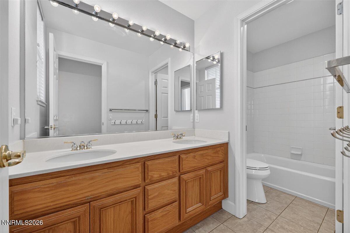 2214 St George Way Carson City, NV 89703 - Photo 39 of 57 a bathroom with a double vanity sink toilet mirror and bathtub