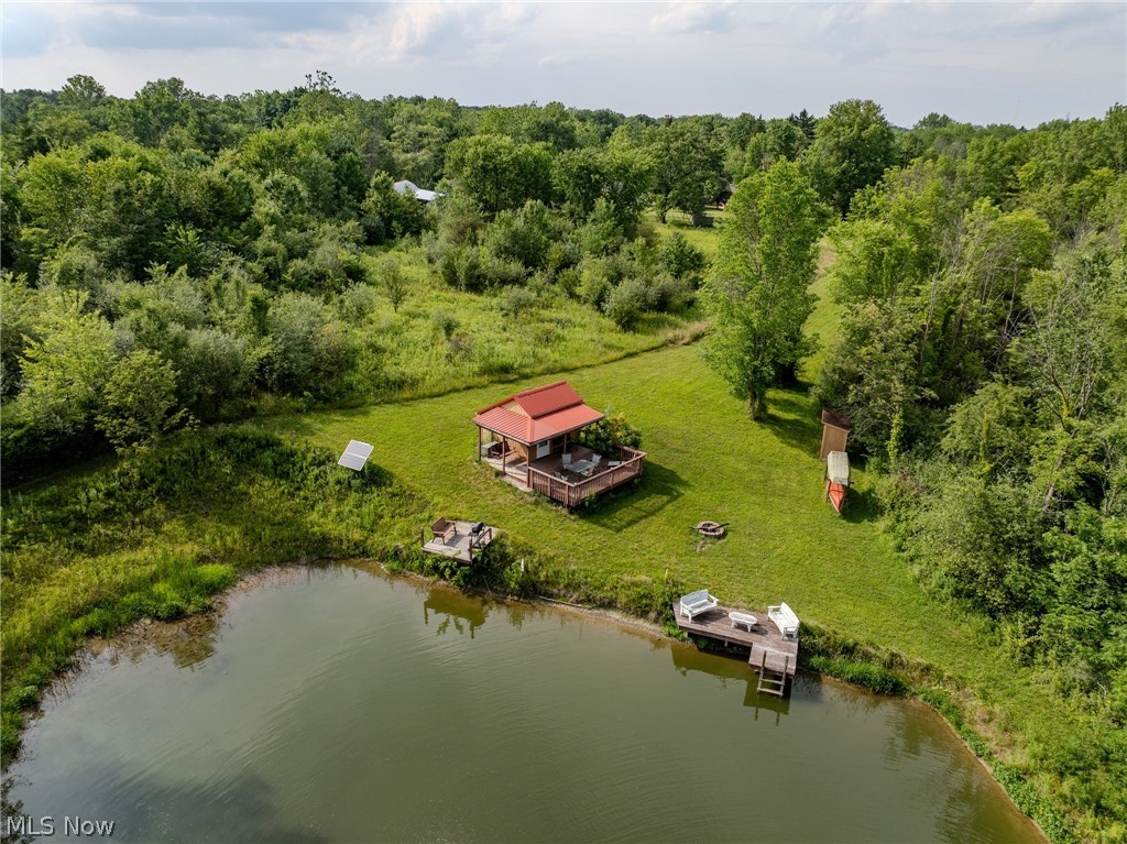 Bennett Road North Royalton, OH 44133 - Photo 20 of 26 Waterfront cabin featuring a red metal roof, covered porch, and expansive lawn