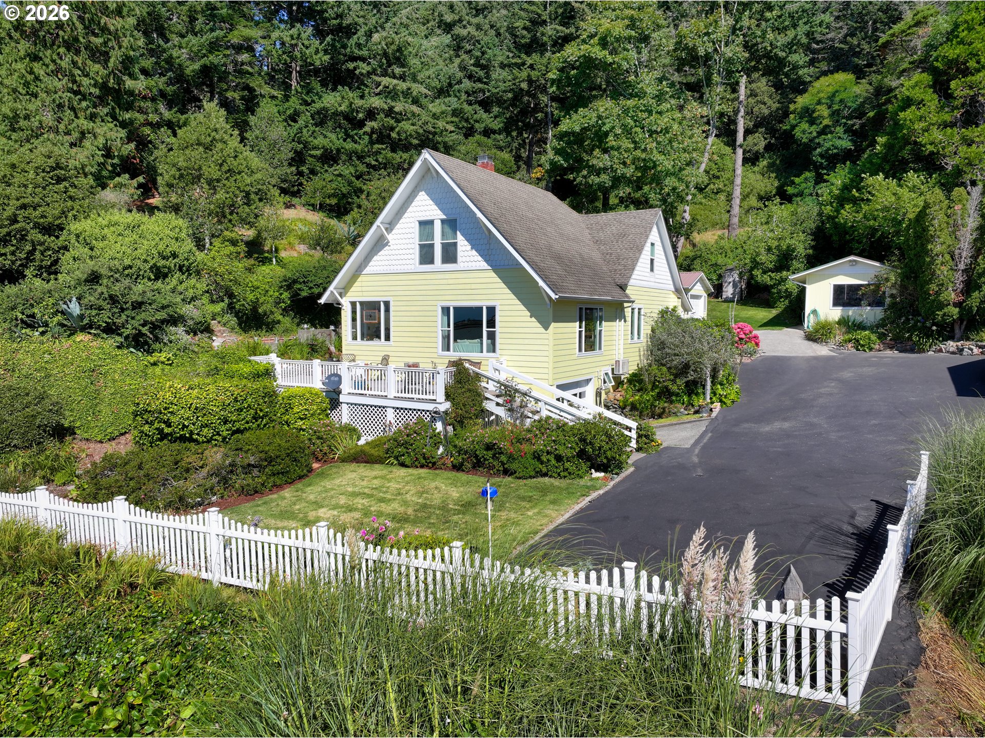 a front view of a house with a yard and potted plants