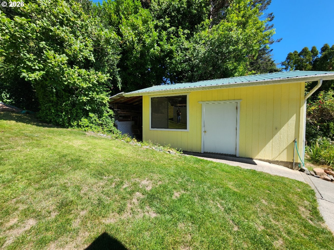 94361 Wedderburn Loop Gold Beach, OR 97444 - Photo 26 of 35 a backyard of a house with plants and large trees