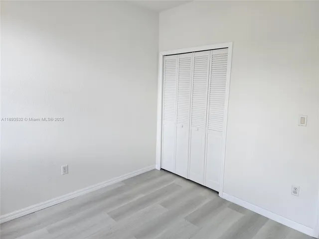 an empty room with a bathroom and mirror