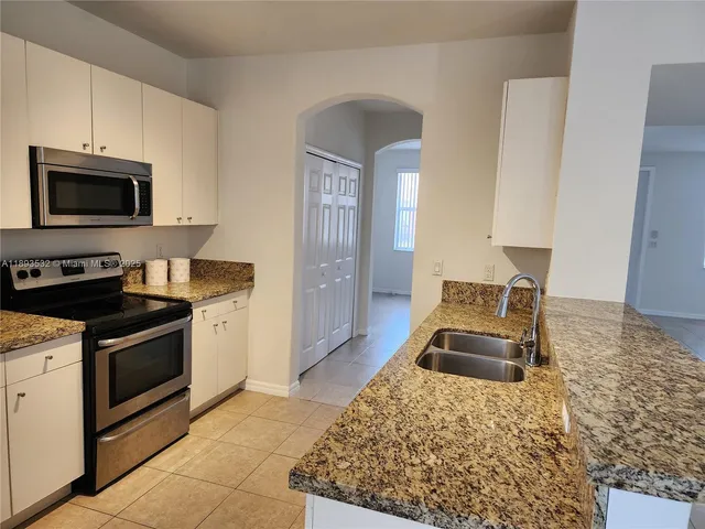 a view of a refrigerator in kitchen and a glass door