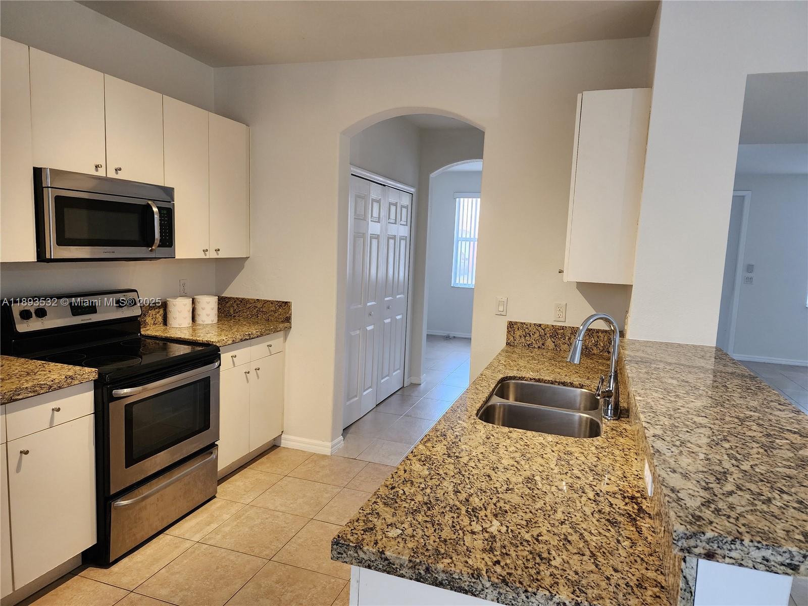 10831 Southwest 240th Lane Homestead, FL 33032 - Photo 9 of 33 a kitchen with a stove and a microwave
