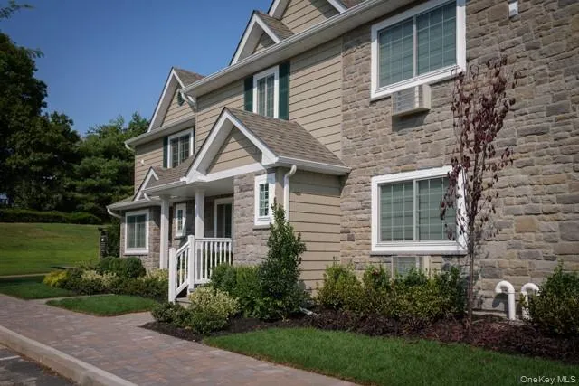 a front view of a house with a yard and green space