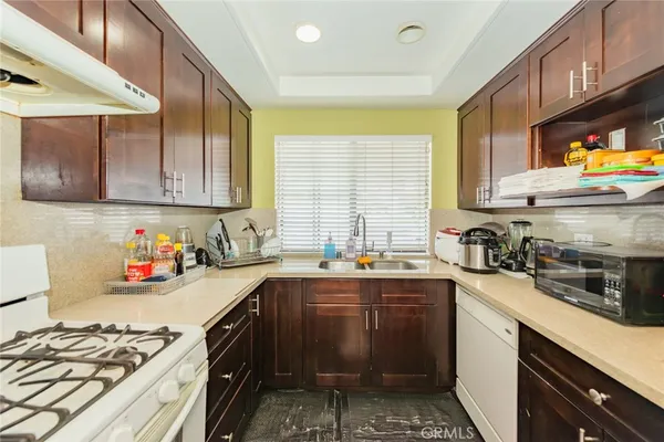 a kitchen with stainless steel appliances a sink a stove and cabinets