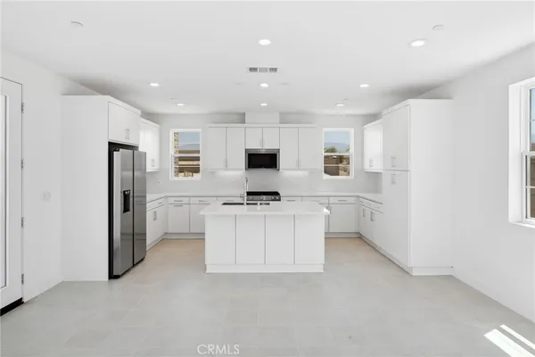 a kitchen with white cabinets and stainless steel appliances