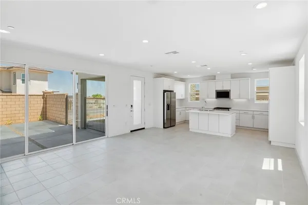 a view of a kitchen with refrigerator and white cabinets