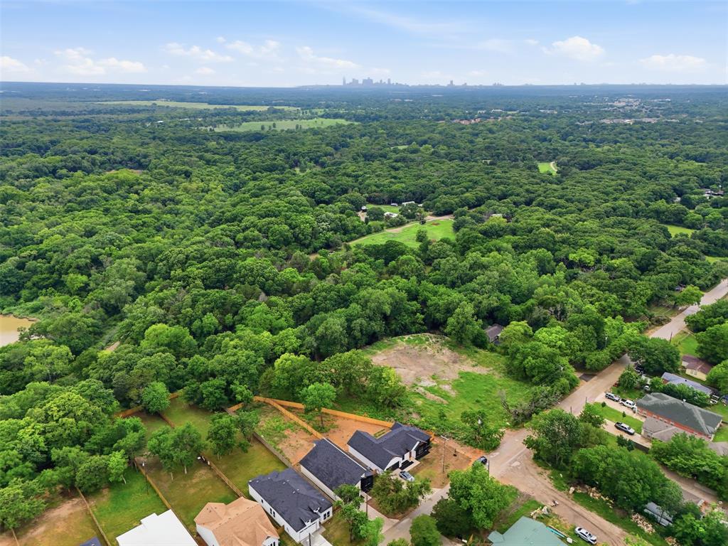 1111 Riverwood Road Dallas, TX 75217 - Photo 39 of 40 Aerial perspective showcasing expansive tree cover and a distant city skyline