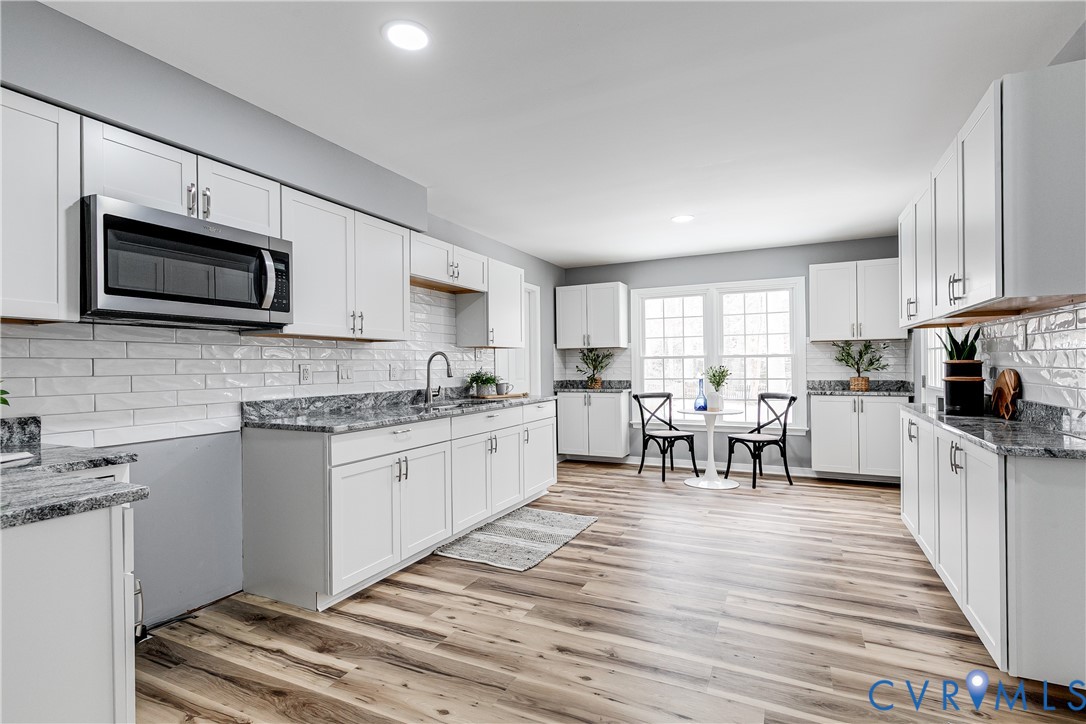7112 Harbourside Court Midlothian, VA 23112 - Photo 17 of 49 a kitchen with stainless steel appliances granite countertop a stove top oven a sink dishwasher a refrigerator and white cabinets with wooden floor