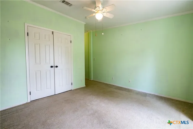 an empty room with a ceiling fan and a window