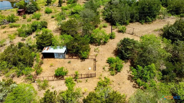 an aerial view of residential house with outdoor space and trees all around