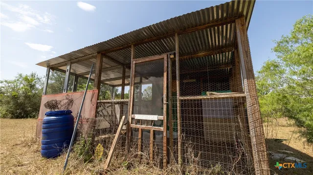 a view of backyard with wooden fence and trees