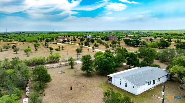 an aerial view of a house with a garden and lake view