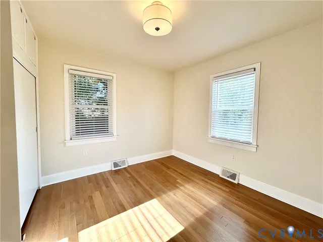 a view of empty room with wooden floor