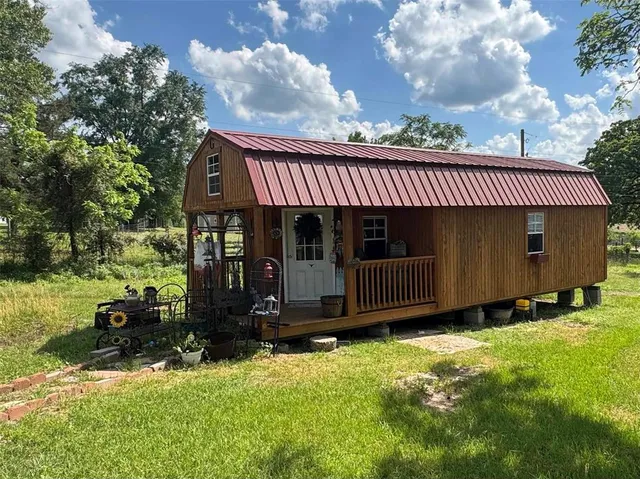 a view of house with backyard and porch