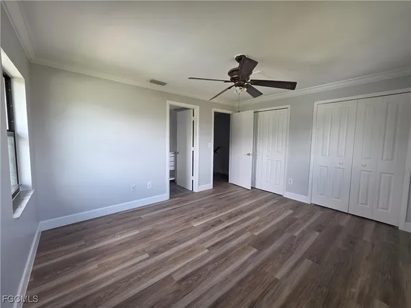 a view of empty room with wooden floor and fan