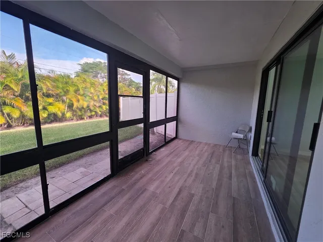 a view of hallway with wooden floor and furniture