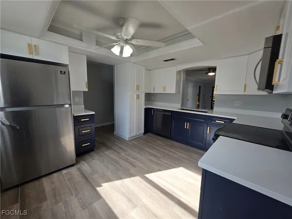 a kitchen with stainless steel appliances granite countertop a refrigerator a sink dishwasher and a stove with wooden floor