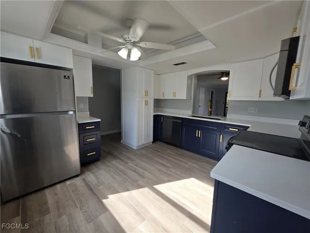 a kitchen with stainless steel appliances granite countertop a refrigerator a sink dishwasher and a stove with wooden floor