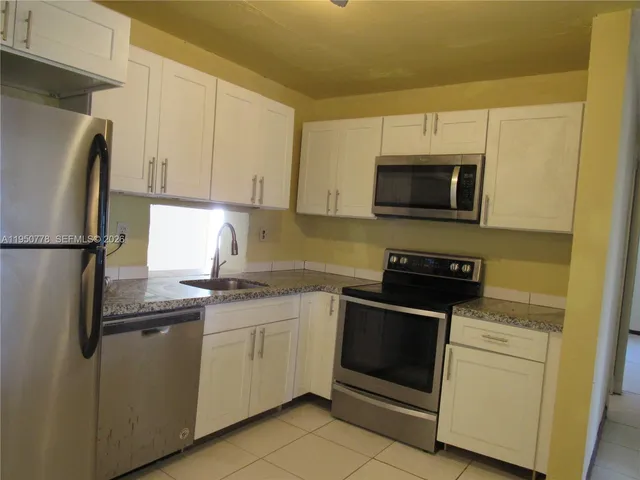 a kitchen with a sink and steel appliances