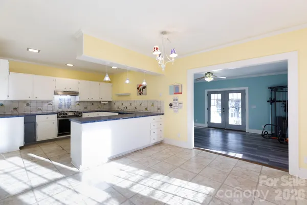 a large white kitchen with a kitchen island sink stainless steel appliances and cabinets