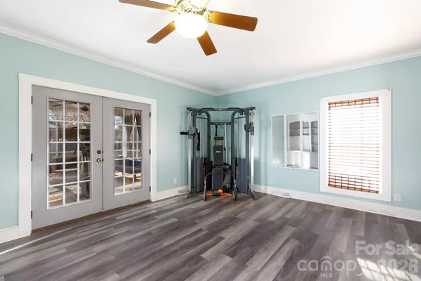 a view of an empty room with a window and wooden floor