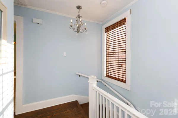 a view of a room with a window and wooden floor