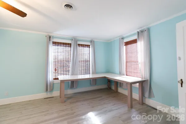 a workspace with wooden floor and windows