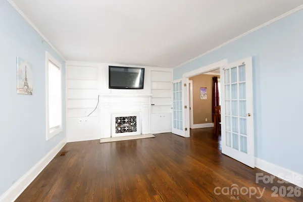 a view of a livingroom with wooden floor and a flat screen tv