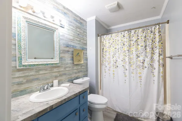 a bathroom with a granite countertop sink toilet and mirror