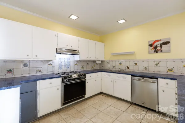 a kitchen with granite countertop white cabinets and white appliances