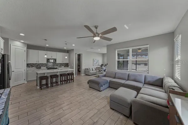 a living room kitchen with furniture and a large window
