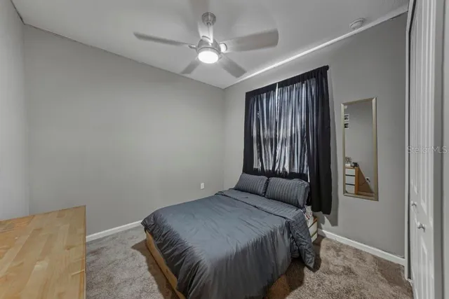a bedroom with a bed and a ceiling fan