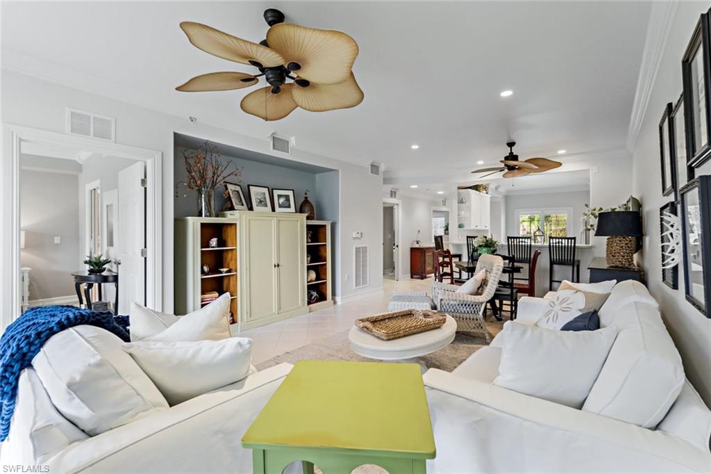 9128 Michael Circle, Unit 9903 Naples, FL 34113 - Photo 15 of 25 a living room with furniture kitchen view and a chandelier