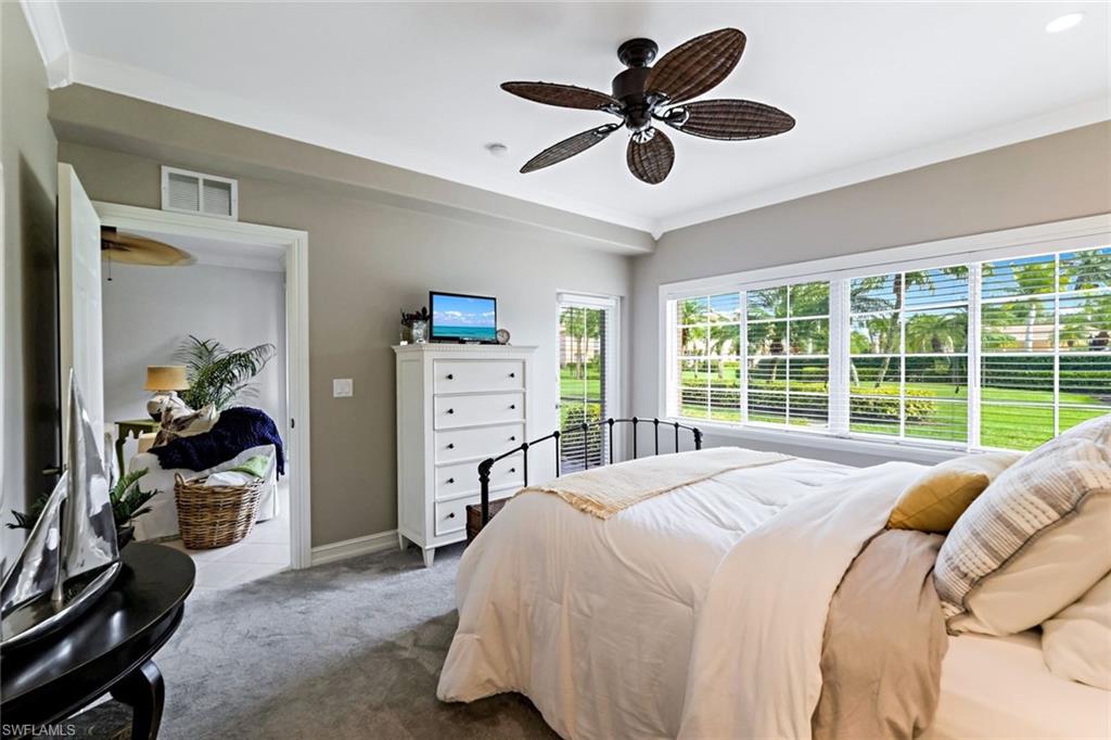 9128 Michael Circle, Unit 9903 Naples, FL 34113 - Photo 16 of 25 a bed sitting in a bedroom next to a window